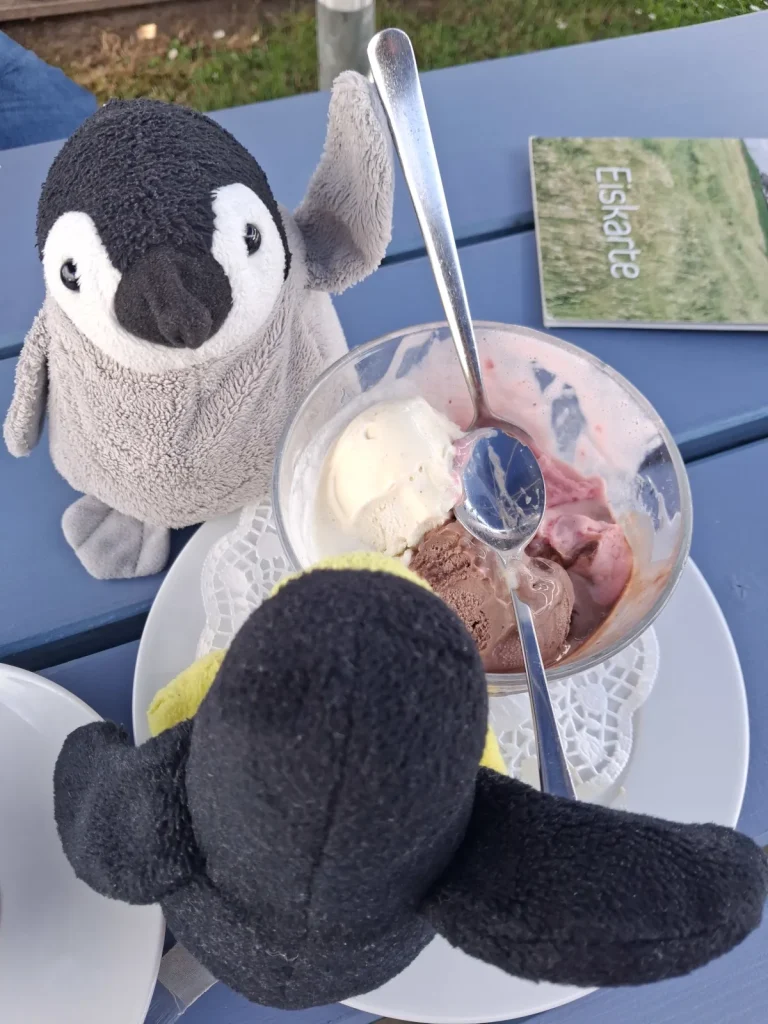 Mütux und Neville essen mit einem großen langen Löffel aus einen Glaseisbecher