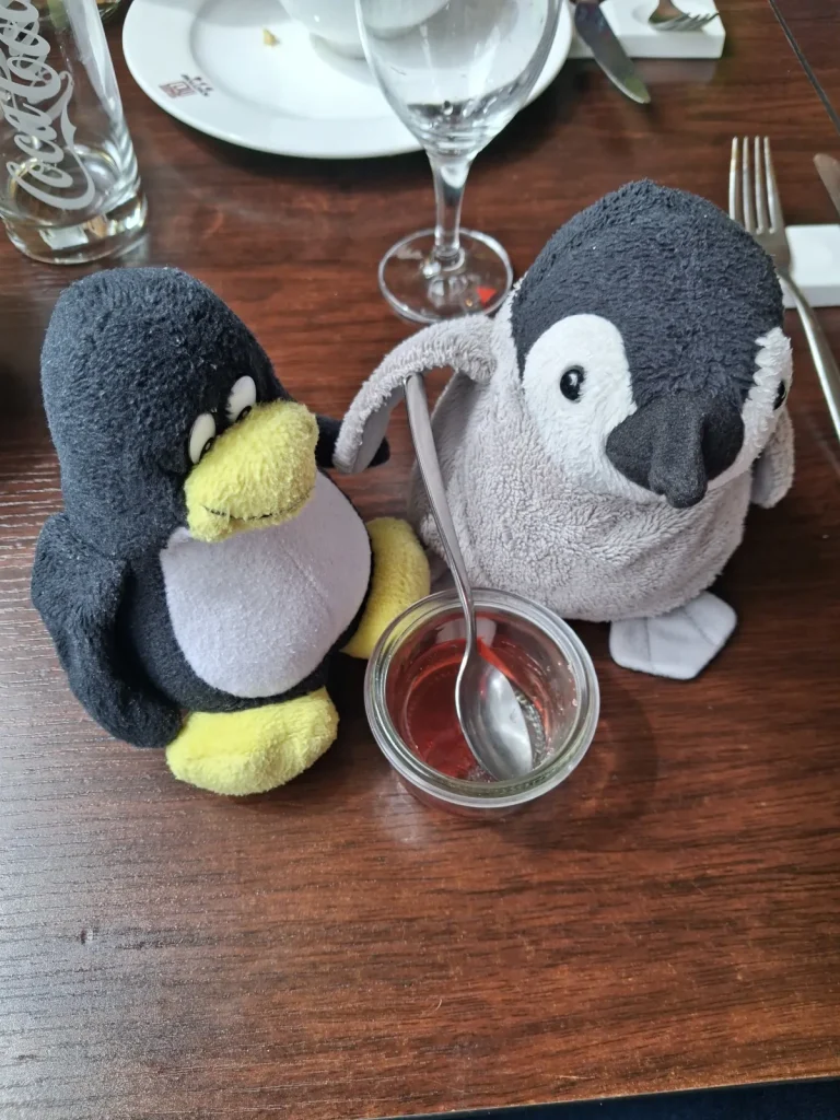 Neville hält den Löffel und beide essen roten Wackelpudding.