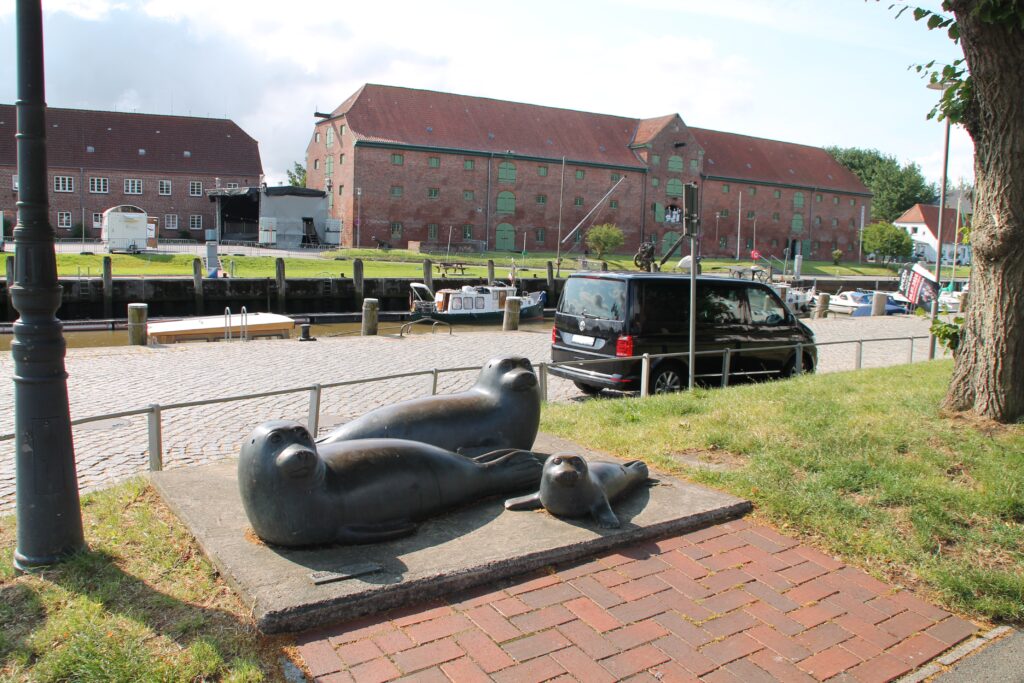 Packhaus im Alten Hafen von Tönning mit 3 Steinseehunden davor