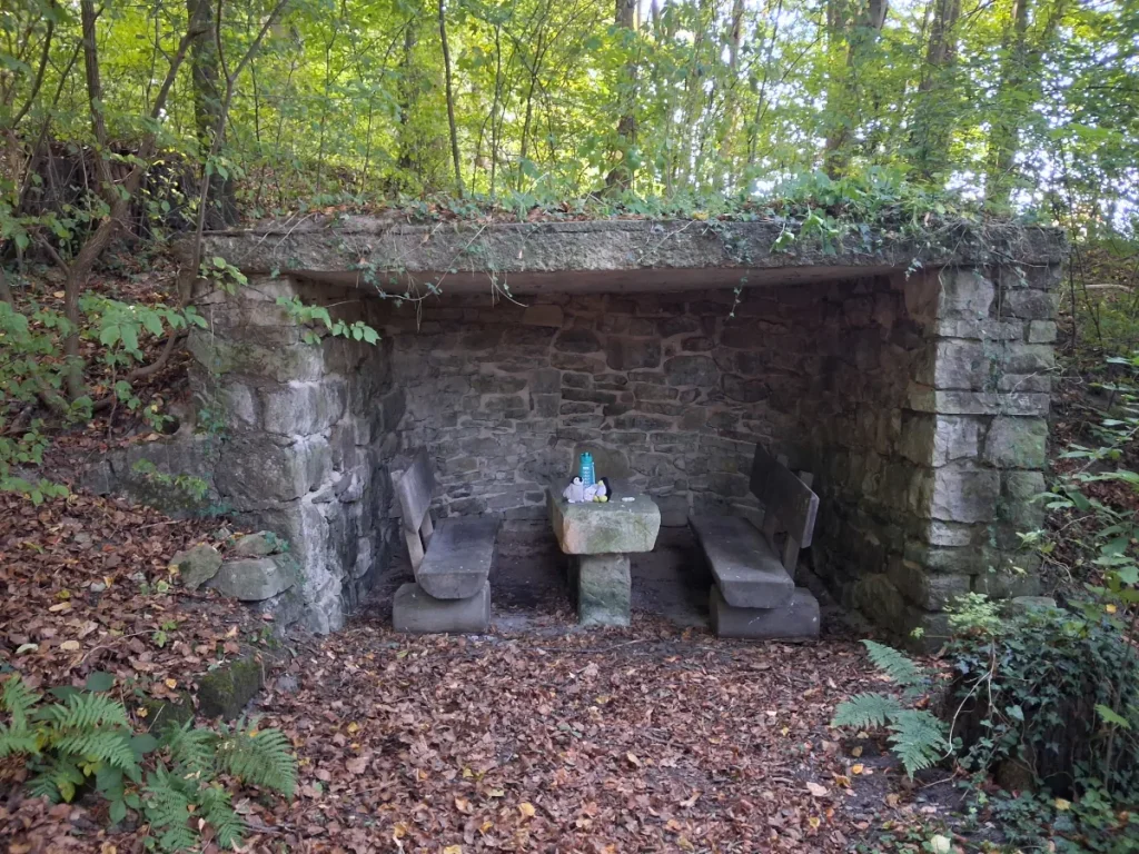 Mütux und Neville im gemütlichen Rastplatz, ein Unterstand aus Naturstein, leicht mit Efeu überwachsen.