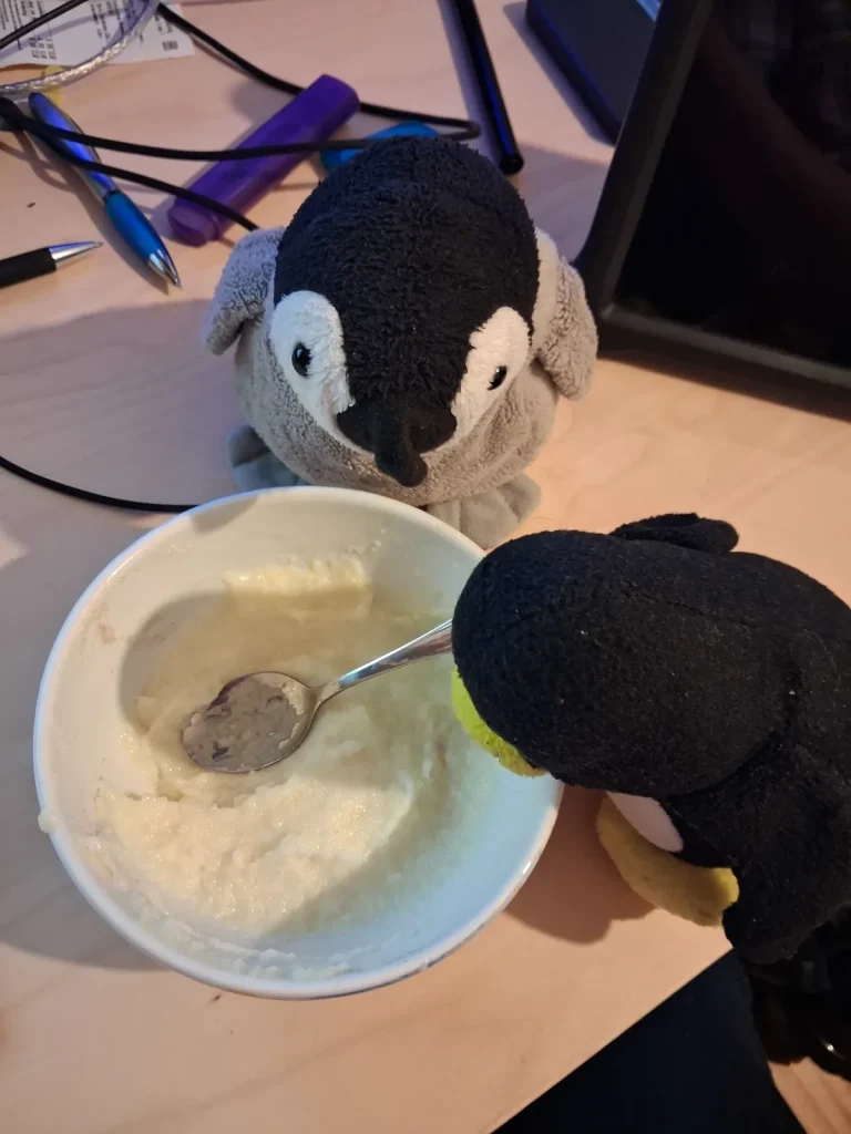 Mütux guckt mit Schnabel voran in die fast leere Schale Grießbrei